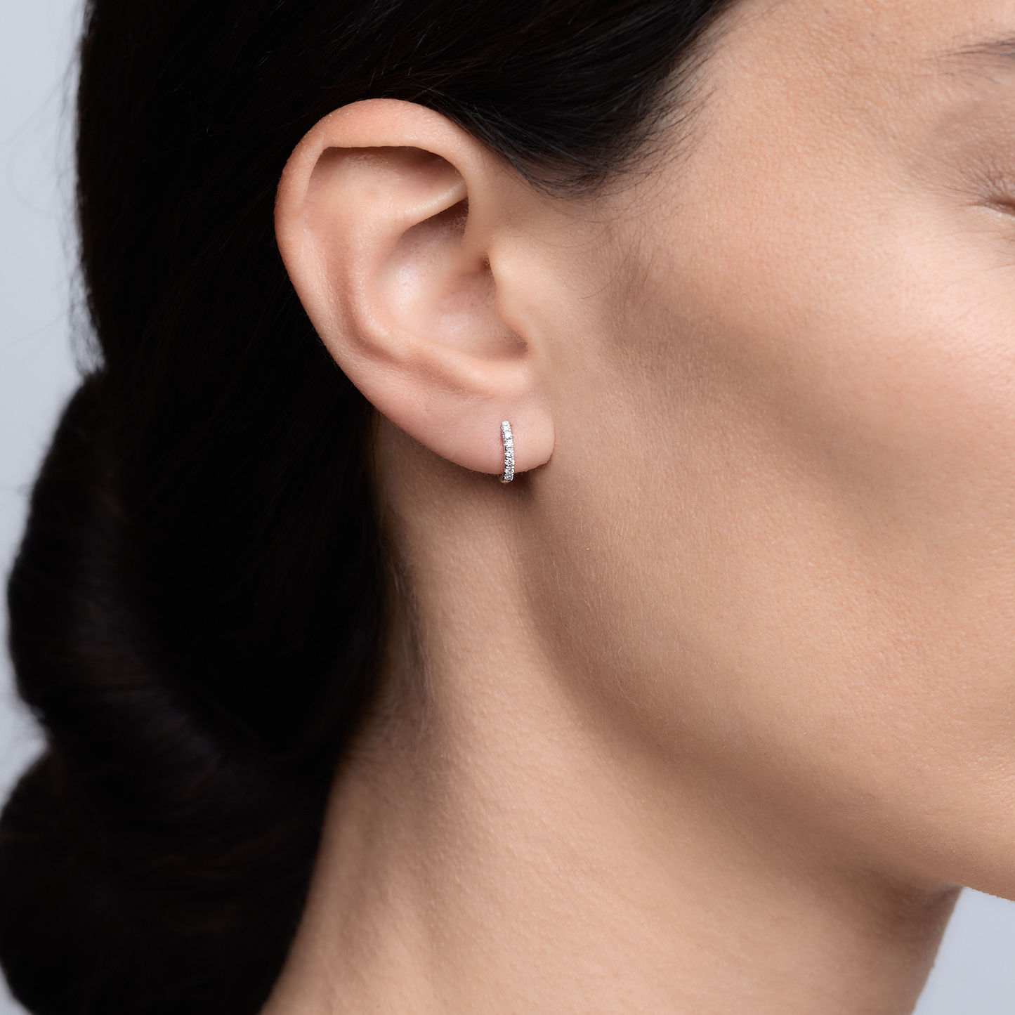 Woman wearing the Oliver Heemeyer Kate Mini Diamond Hoops 9,0 mm made of white gold.