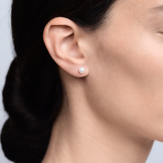 Woman wearing the Oliver Heemeyer Pearl Ear Studs made of 18k white gold.