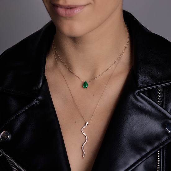 Woman wearing the Oliver Heemeyer Snake diamond necklace made of 18k rose gold combined with the Oliver Heemeyer Dragon Tear emerald necklace.