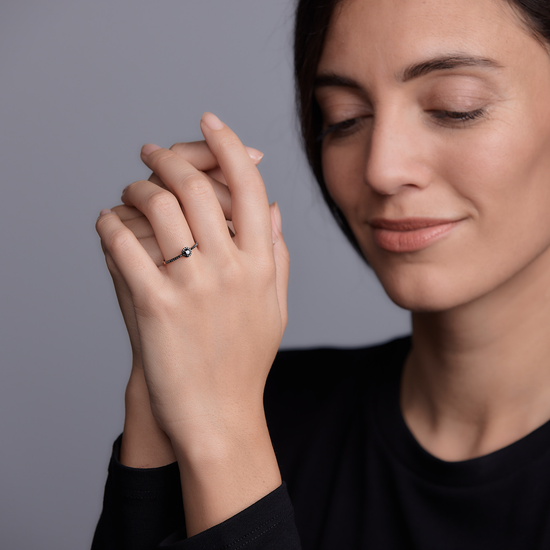 Woman wearing the Oliver Heemeyer Liz black diamond ring 0.28 ct. made of 18k rose gold.