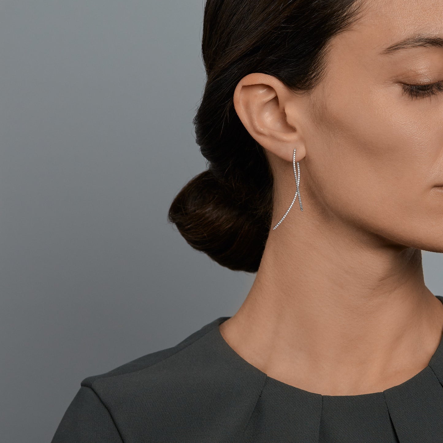 Woman wearing the Oliver Heeeyer Wave diamond earrings in 18k white gold.