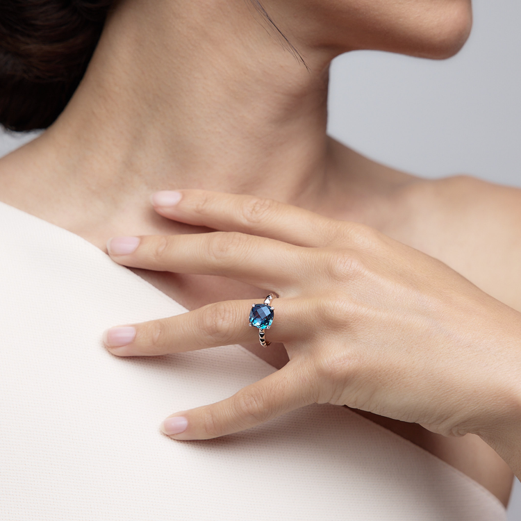 Woman wearing the Charlie London Blue Topaz Ring made of 18k white gold.
