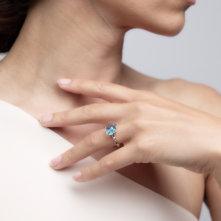 Woman wearing the Oliver Heemeyer Charlie Swiss Blue Topaz Ring made of 18k white gold.