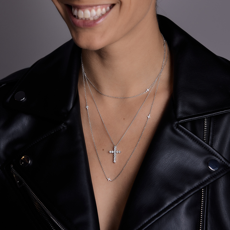 Woman wearing the Oliver Heemeyer diamond cross necklace fancy 1.00 ct. made of 18k white gold combined with the Oliver Heemeyer diamond cross infinity necklace.