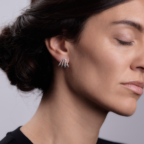 Woman wearing the Oliver Heemeyer Hallie diamond ear studs made of 18k white gold.