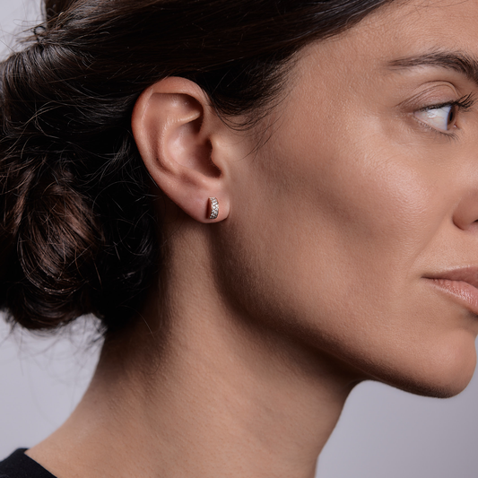 Woman wearing the Oliver Heemeyer Demi diamond ear studs made of 18k rose gold.