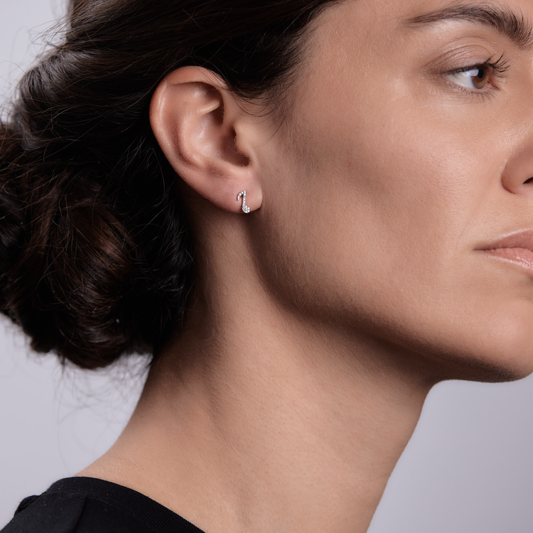 Woman wearing the Oliver Heemeyer Cosi diamond ear studs made of 18k white gold.