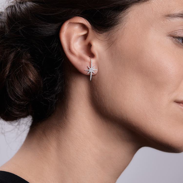 Woman wearing the Oliver Heemeyer North Star diamond ear stud made of 18k white gold.