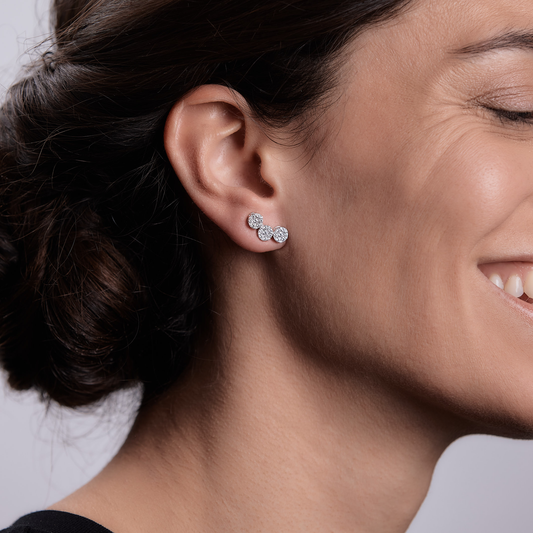Woman wearing the Oliver Heemeyer Kelly diamond ear studs made of 18k white gold.