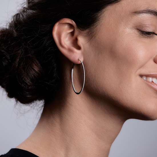 Woman wearing the Oliver Heemeyer Oakley diamond hoops 4,5 cm made of 18k white gold.