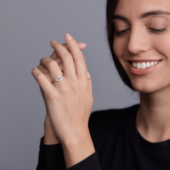 Woman wearing the Oliver Heemeyer The Kiss diamond ring made of 18k white gold.
