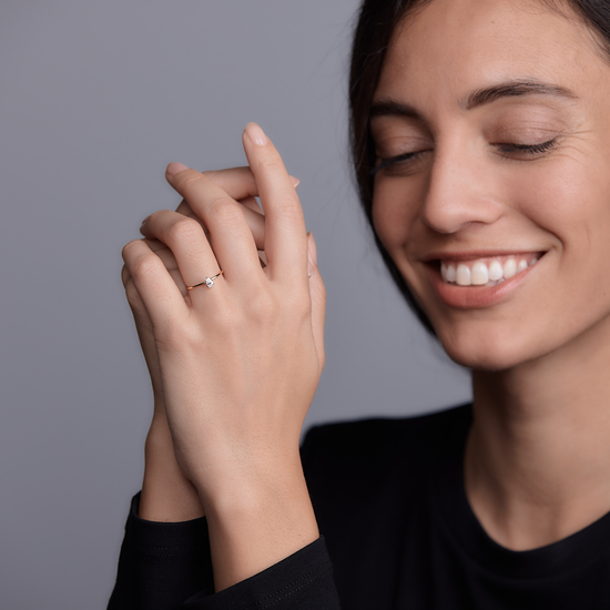 Woman wearing the Oliver Heemeyer diamond drop ring made of 18k rose gold.