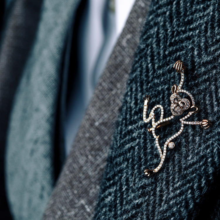 Man wearing Monkey diamond brooch from Oliver Heemeyer. Handcrafted, made of 18k rose gold and set with 126 diamonds.