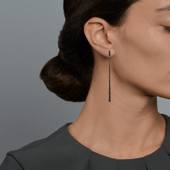 Woman wearing the Oliver Heemeyer Line diamond earrings in 18k rose gold with black diamonds.