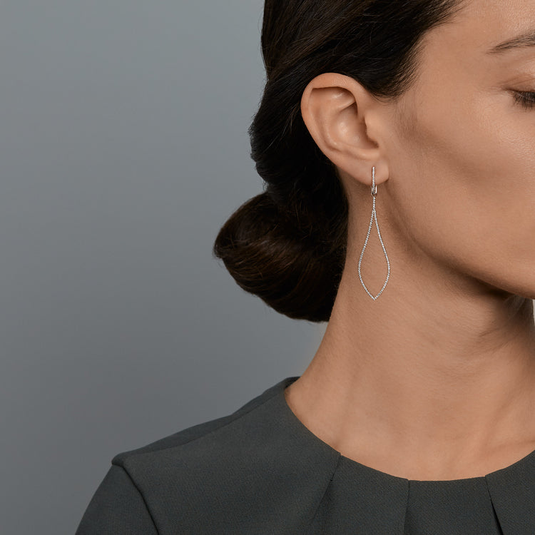 Woman wearing the Oliver Heemeyer Eye diamond earrings in 18k white gold.
