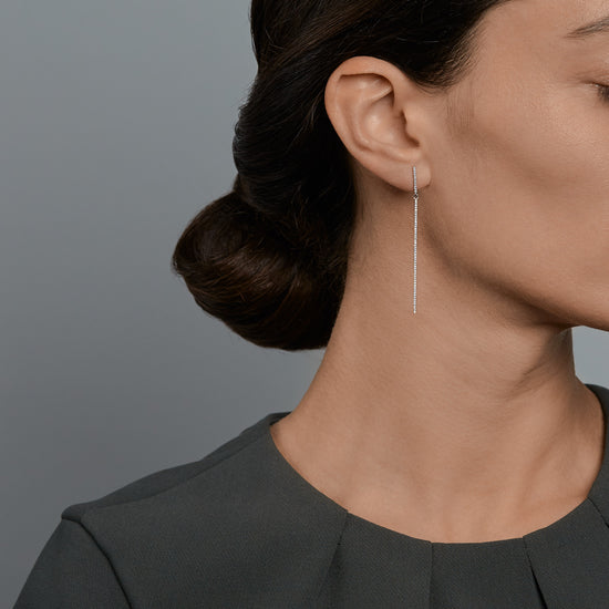 Woman wearing the Oliver Heemeyer Bar diamond earrings in 18k white gold.