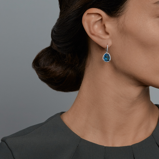 Woman wearing the Oliver Heemeyer Jamie London Blue Topaz Earrings made of 18k white gold.
