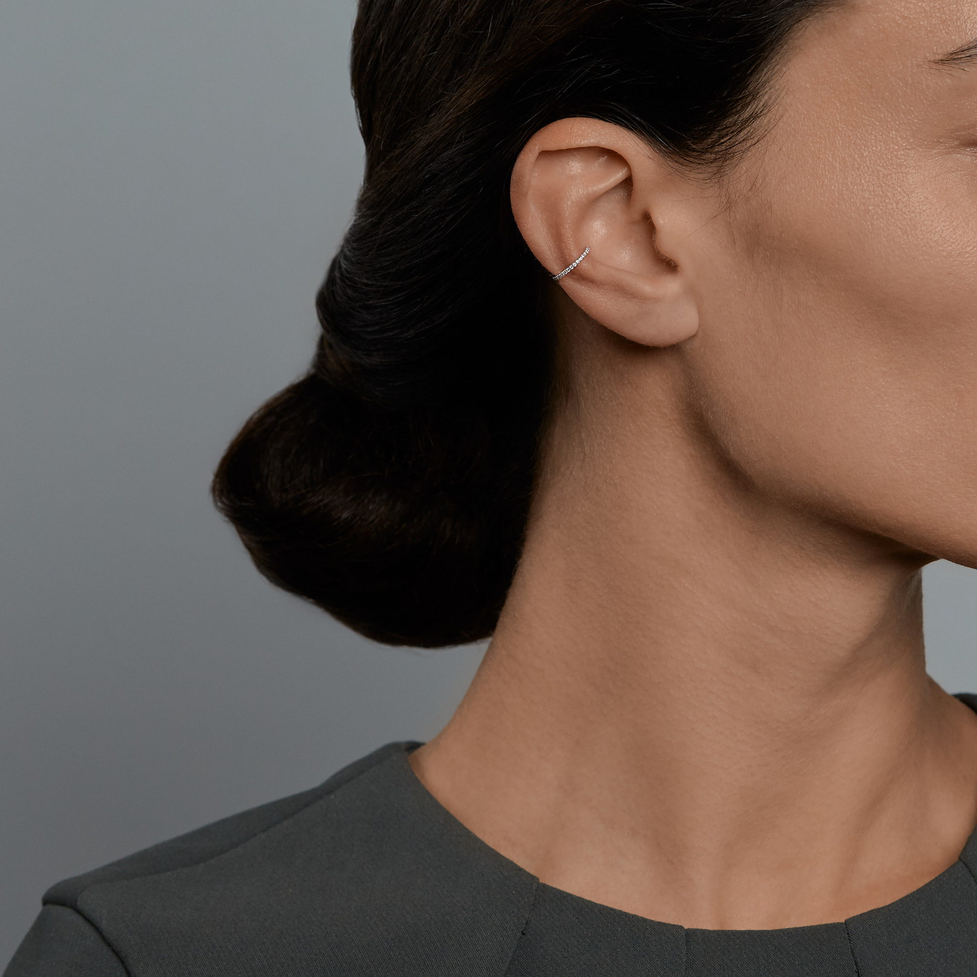 Woman wearing the Oliver Heemeyer Lilly Diamond Ear Cuff 1 Row made of 18k white gold.