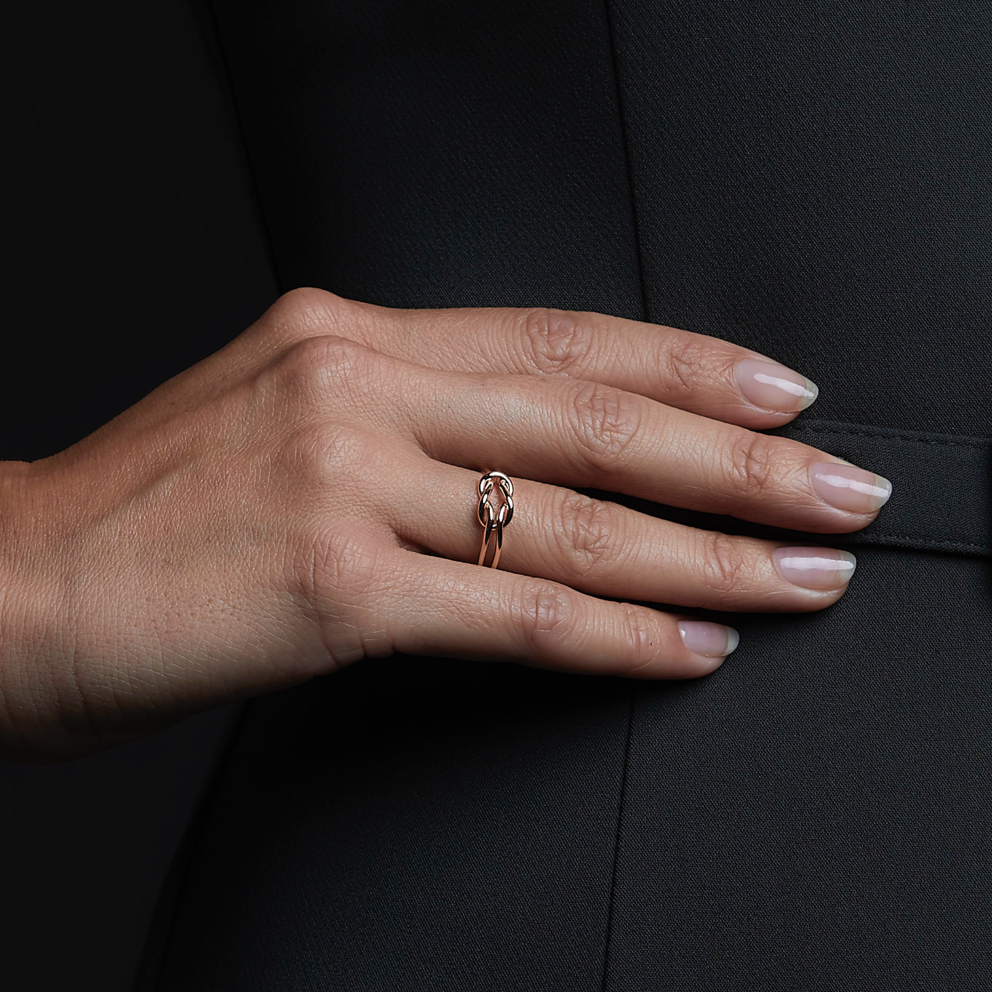 Woman wearing the Oliver Heemeyer Knot ring in 18k rose gold. Close up.