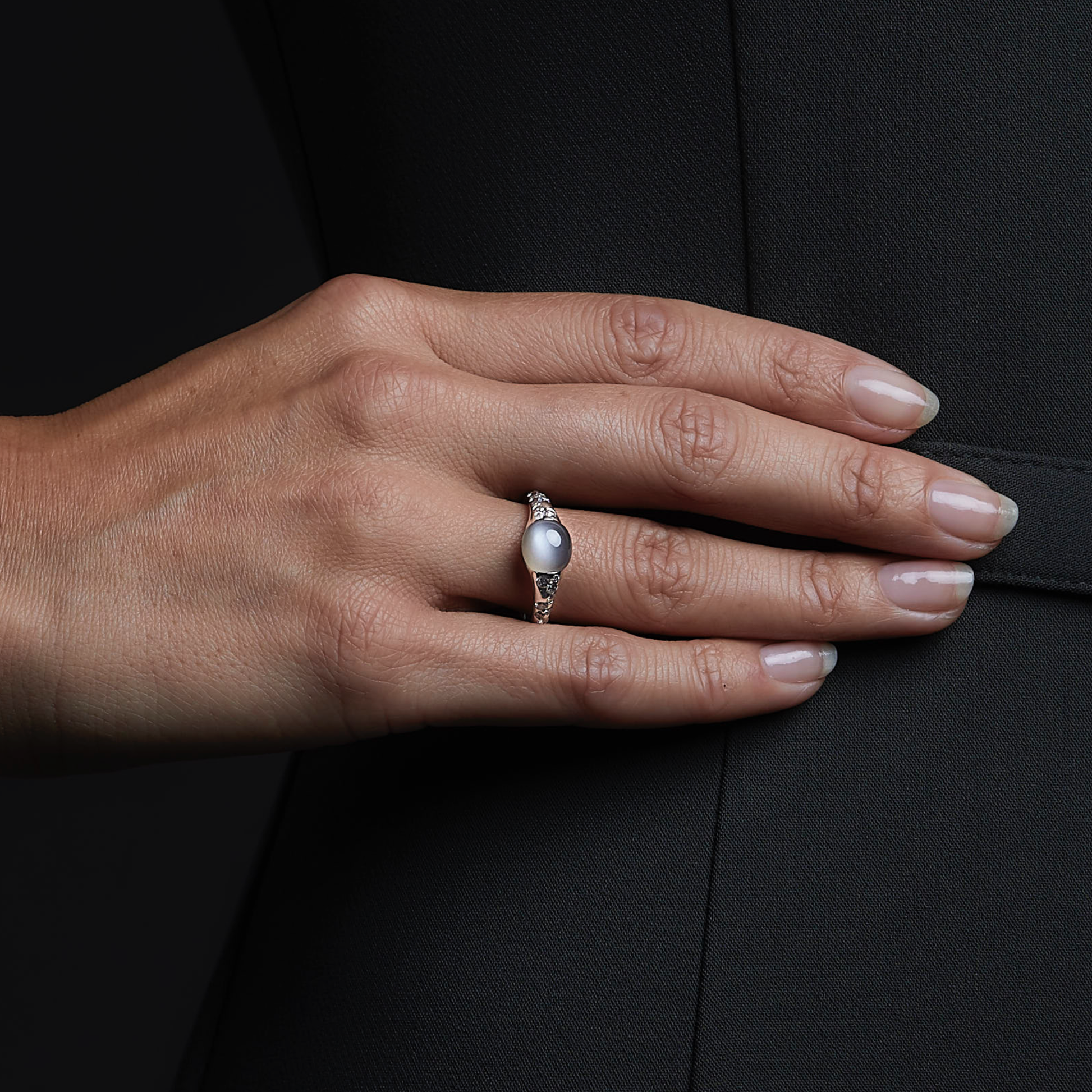 Woman wearing the Oliver Heemeyer Moonstone diamond ring in 18k white gold with grey moonstone. Close up.