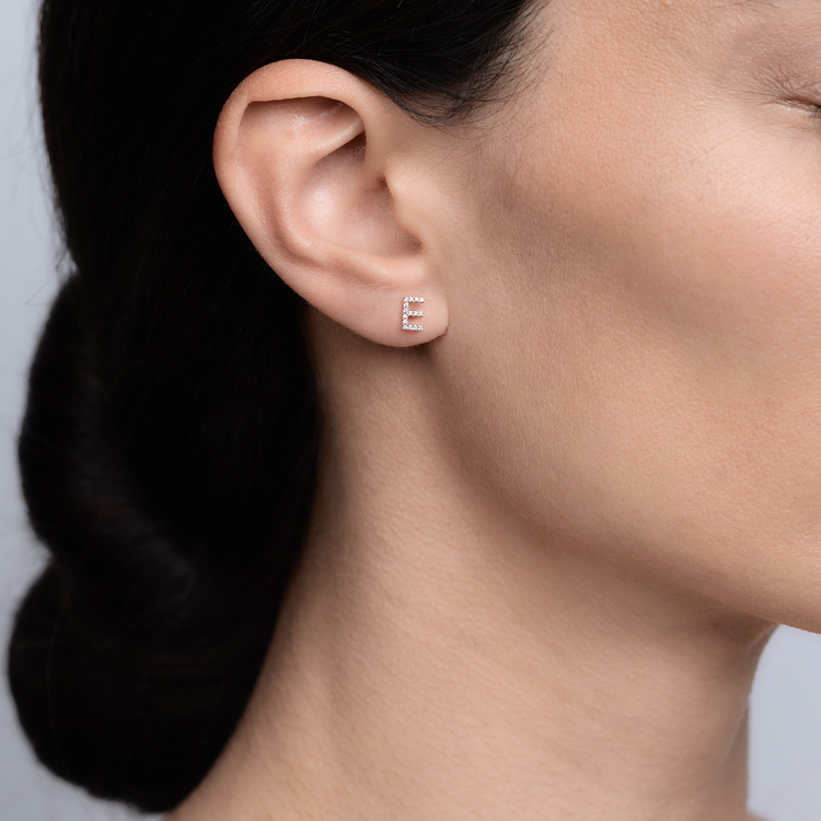 Woman wearing the Oliver Heemeyer Letter diamond ear stud made of 18k rose gold.