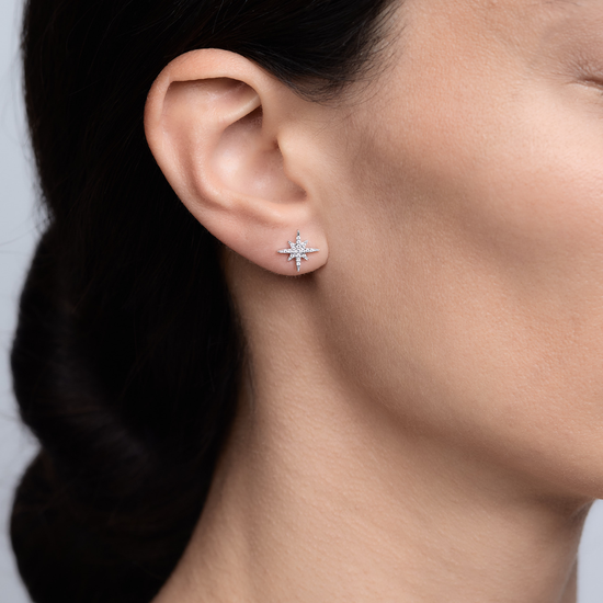 Woman wearing the Oliver Heemeyer North Star diamond ear stud small made of 18k white gold.