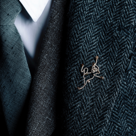 Man wearing Monkey diamond brooch from Oliver Heemeyer. Handcrafted, made of 18k rose gold and set with 126 diamonds. Different perspective.