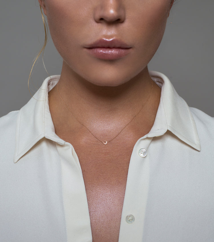 Woman wearing the Oliver Heemeyer Moon diamond pendant designed in 18k rose gold, crafted with three small and sparkling diamonds. A delightful piece of jewelry wearable on any occasion.